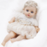 Păpușă Reborn Interactivă Blondă cu Rochie Albă și Voce – 35 cm