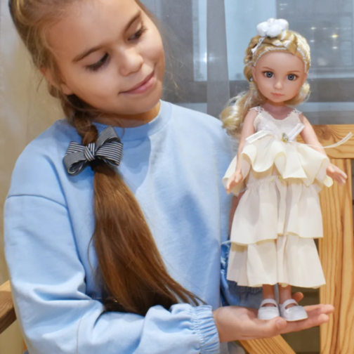 Păpușă Sennby Baby cu Rochie Alb-Crem și Accesoriu Elegant – 35 cm